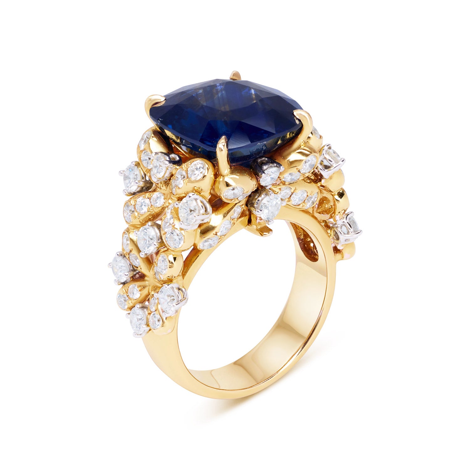 A luxurious interchangeable necklace and ring set featuring a royal blue Ceylon sapphire, surrounded by a floral wreath of golden florals with white diamonds, all in 18k yellow gold.