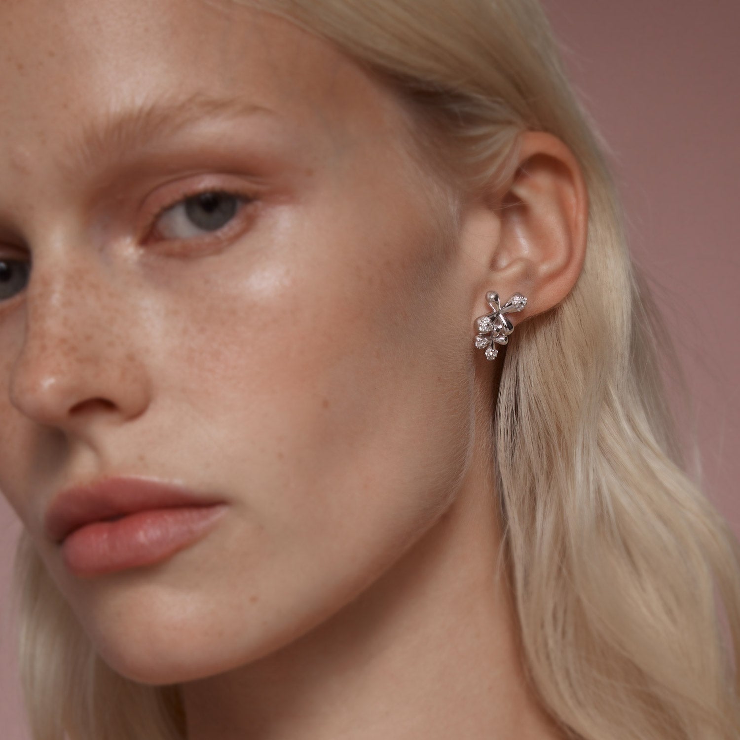 Maxi Diamond Stud Earrings in 18k white gold with 24 diamonds totaling 1.00ct and floral motifs, worn on model.