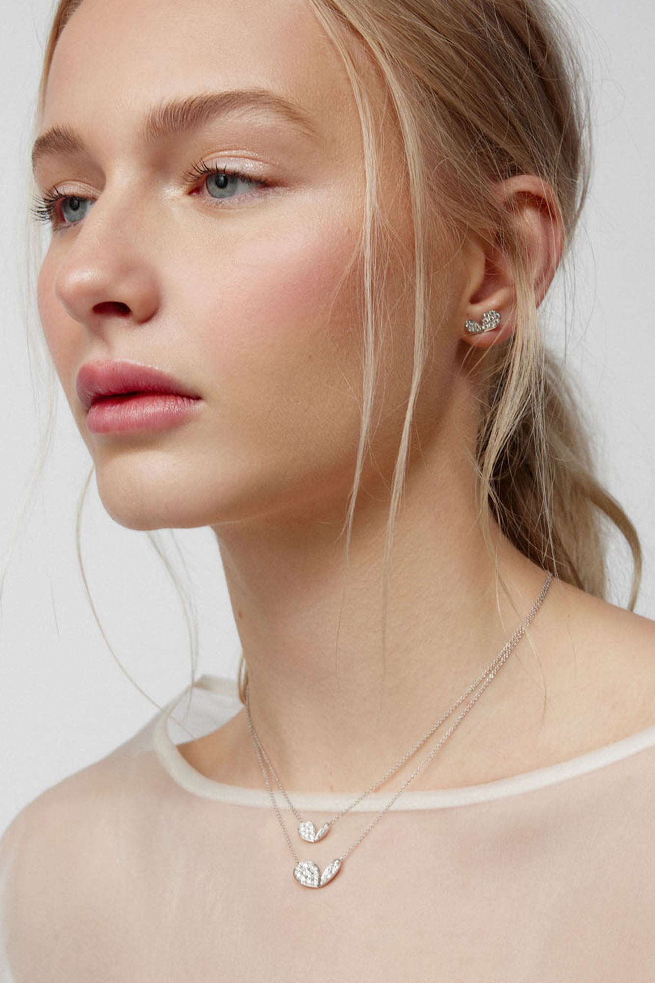 Faith jewels Diamond pavé white gold stud earrings and necklace pendants in a stylized petal design, evoking hearts, butterflies, or wings