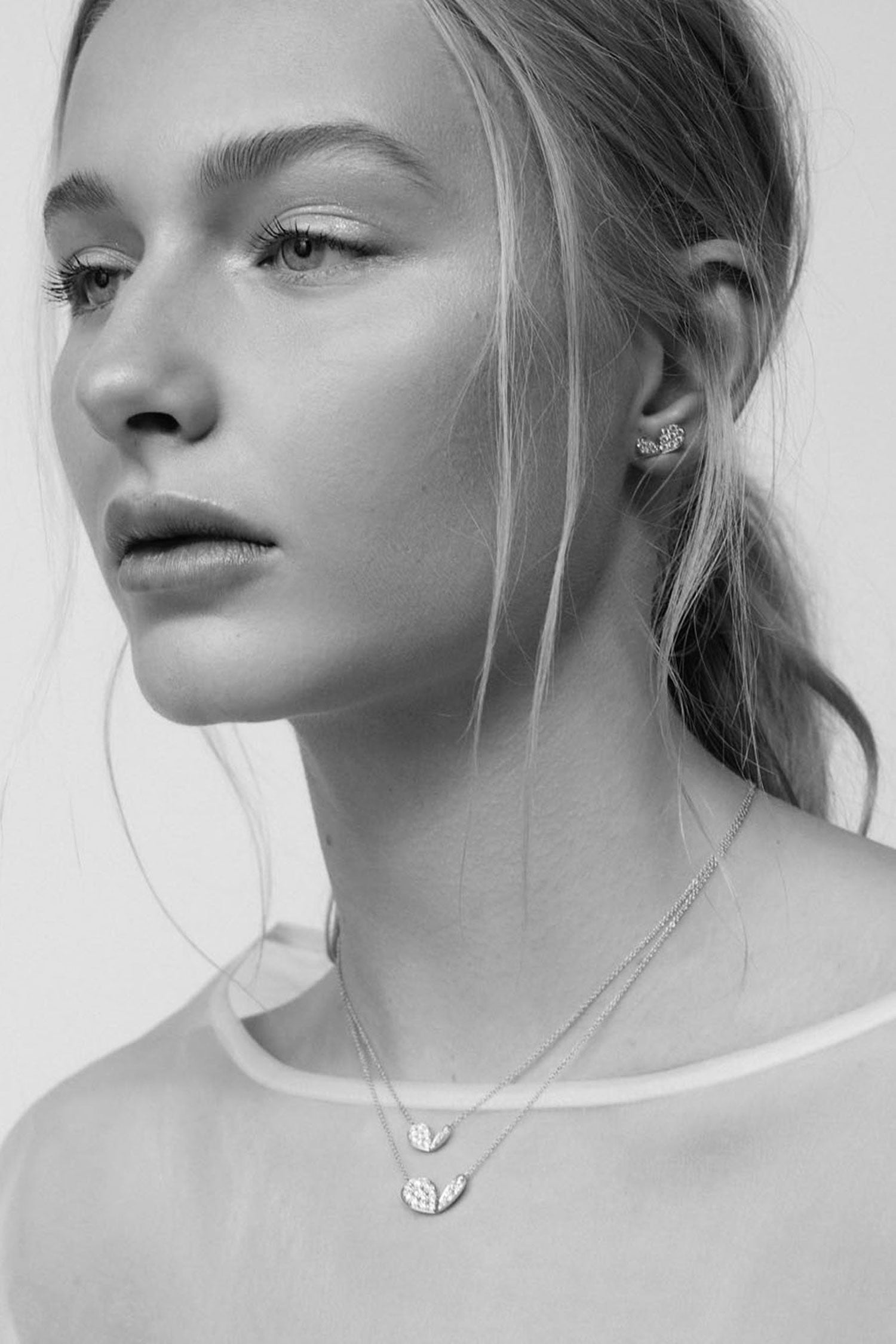 Faith Jewels 18k white gold necklace with a mini pavé diamond lily petal motif in two different sizes, worn with matching studs