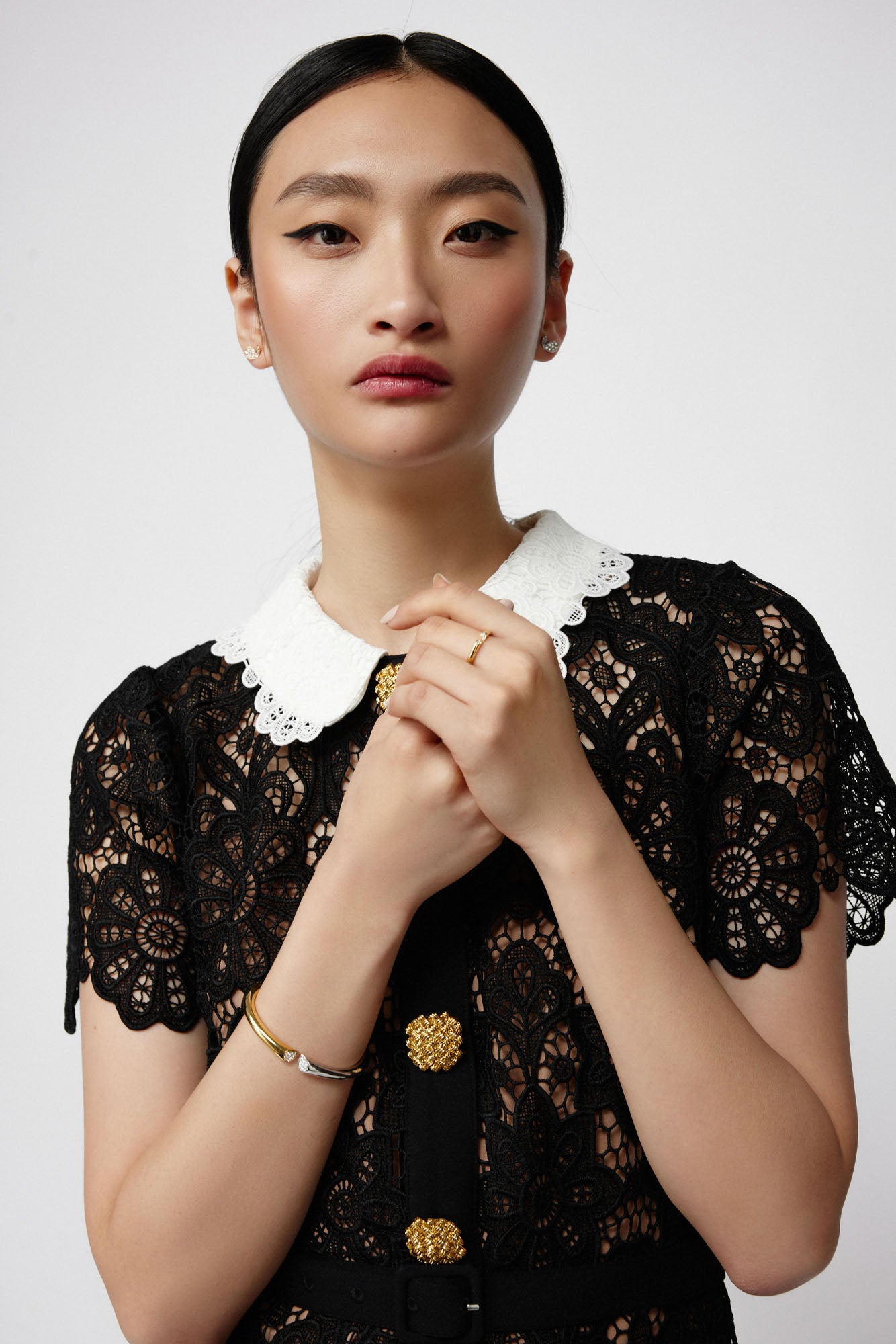 Faith Jewels two-tone 18k gold bangle with 0.20ct pavé diamonds, featuring a heart-shaped lily petal design and hinge closure, worn with matching studs and ring