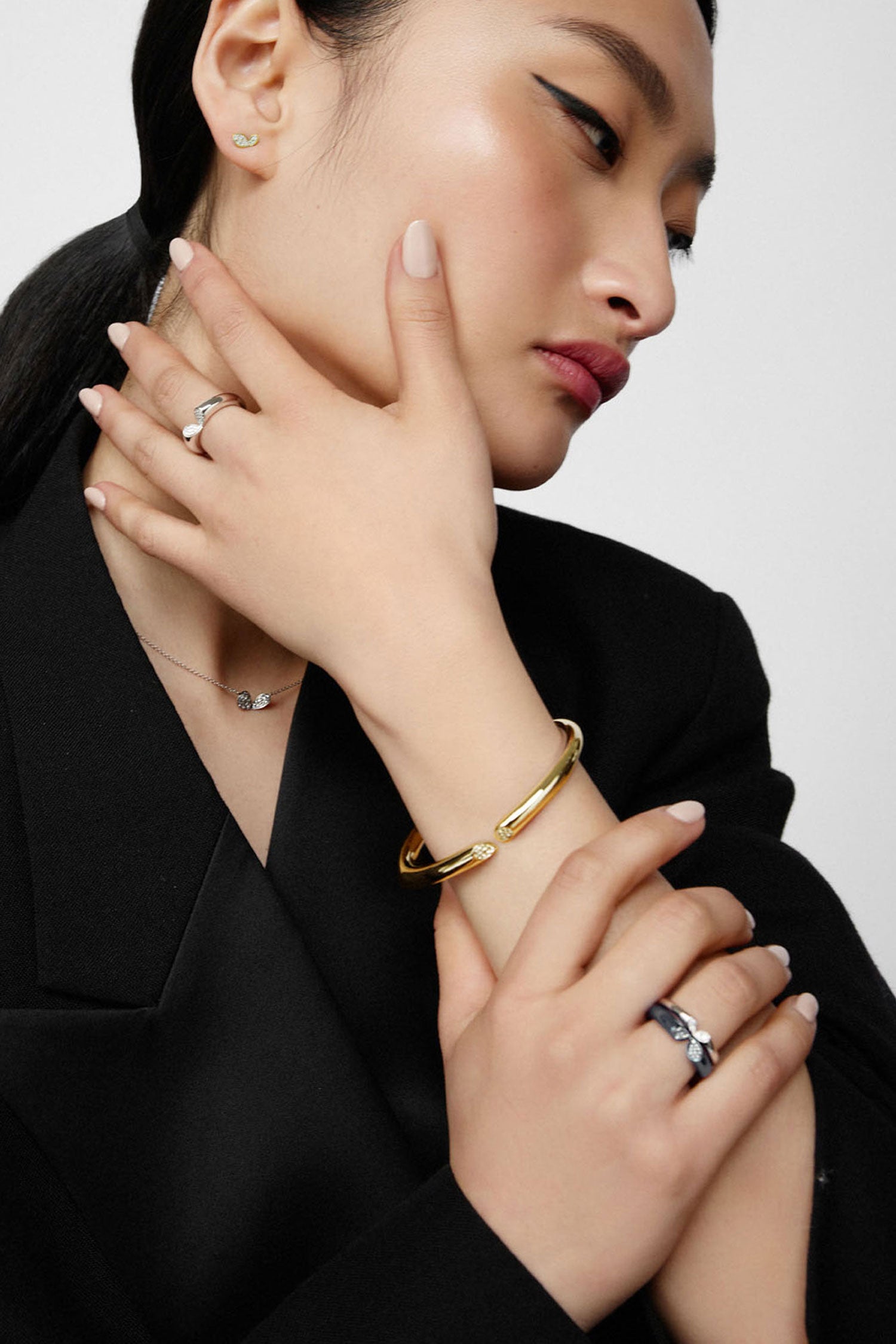 Faith jewels whispers of love collection yellow gold mini stud earrings worn with matching white gold pendant necklace, stacked rings and yellow gold bangle