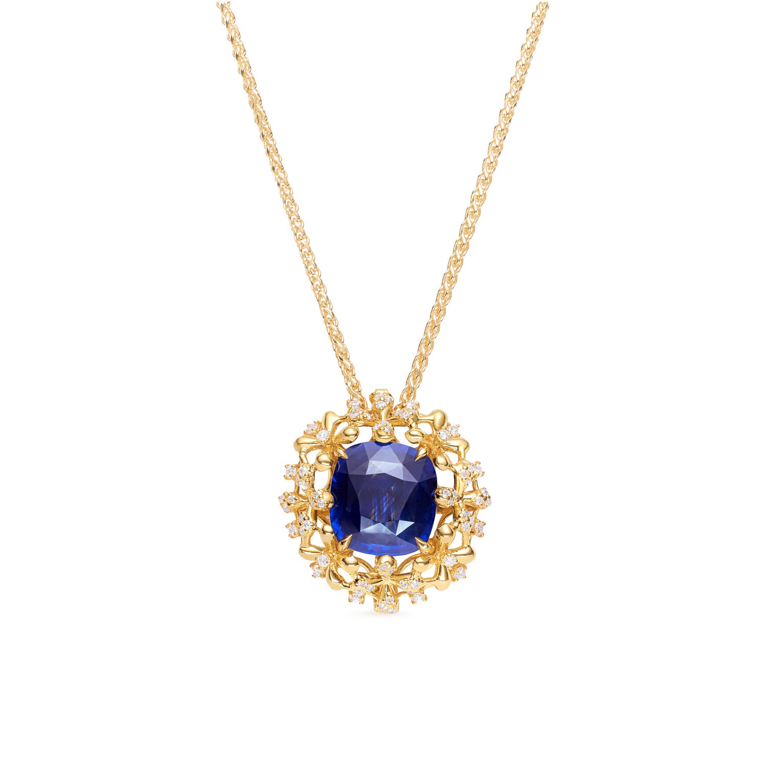 A luxurious interchangeable necklace and ring set featuring a royal blue Ceylon sapphire, surrounded by a floral wreath of golden florals with white diamonds, all in 18k yellow gold.