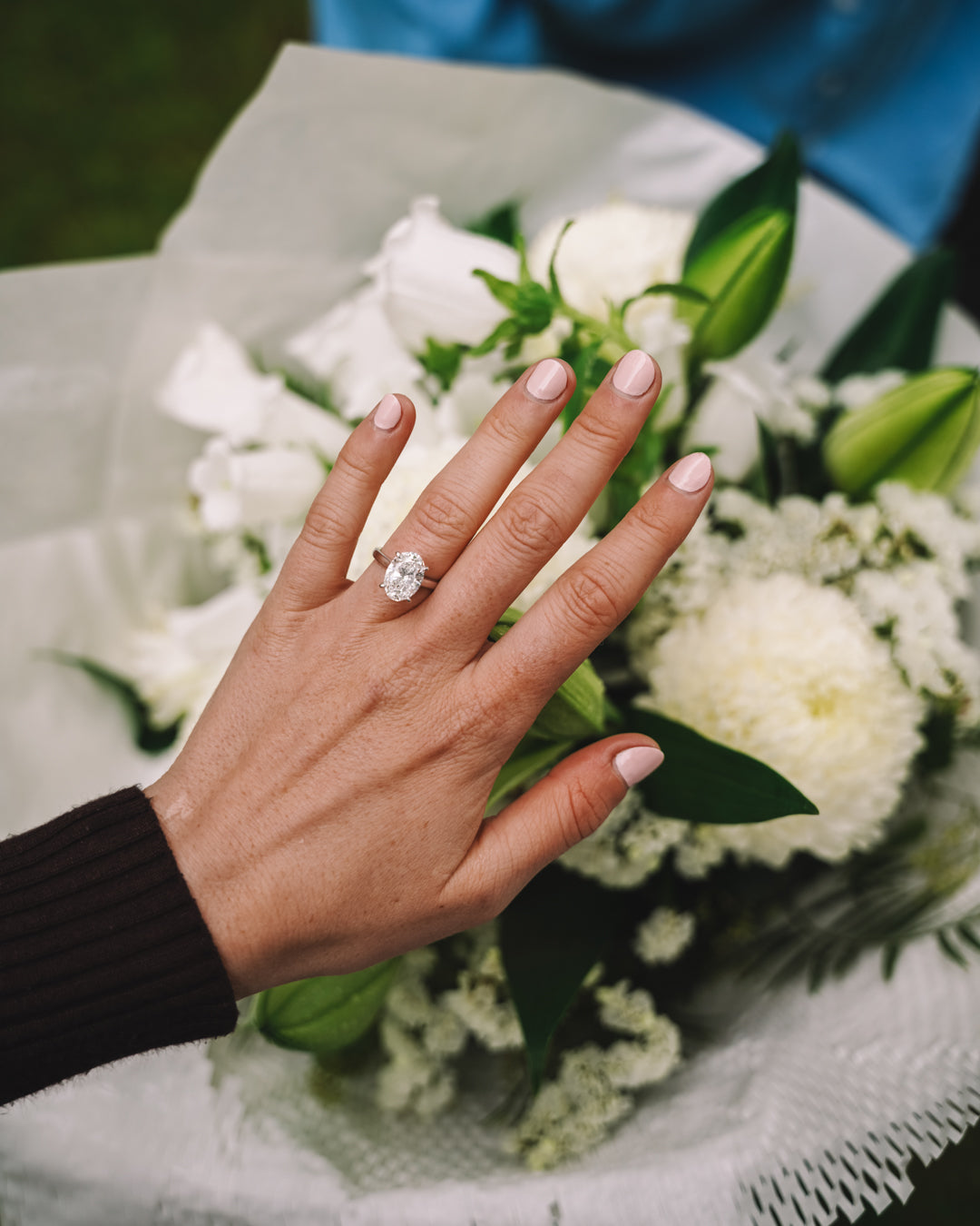 18k white gold engagement ring with 3.72ct oval-cut diamond, elegant band, worn on hand.