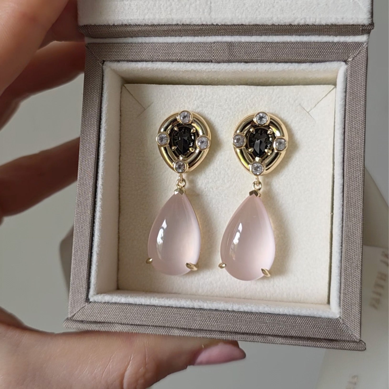 Bespoke pear-shaped rose quartz and black onyx cabochon earrings in 18k yellow gold, modern elegance.