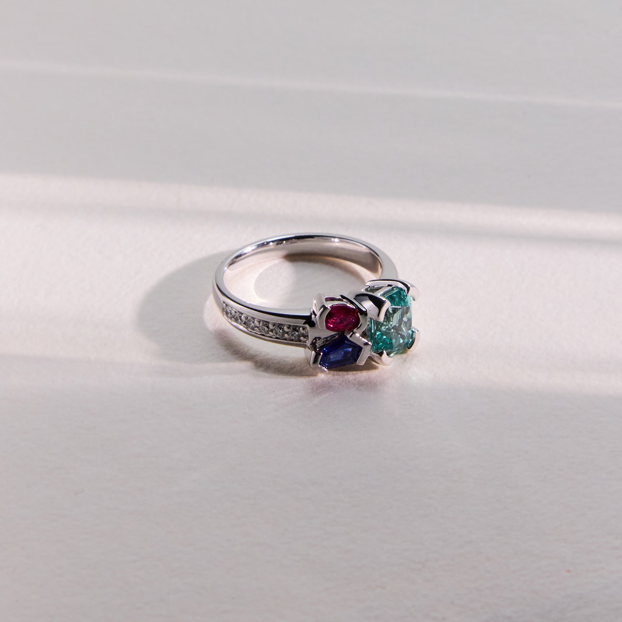 White gold Kelly Bouquet ring featuring ruby, Paraiba tourmaline, blue sapphire, and diamond accents.