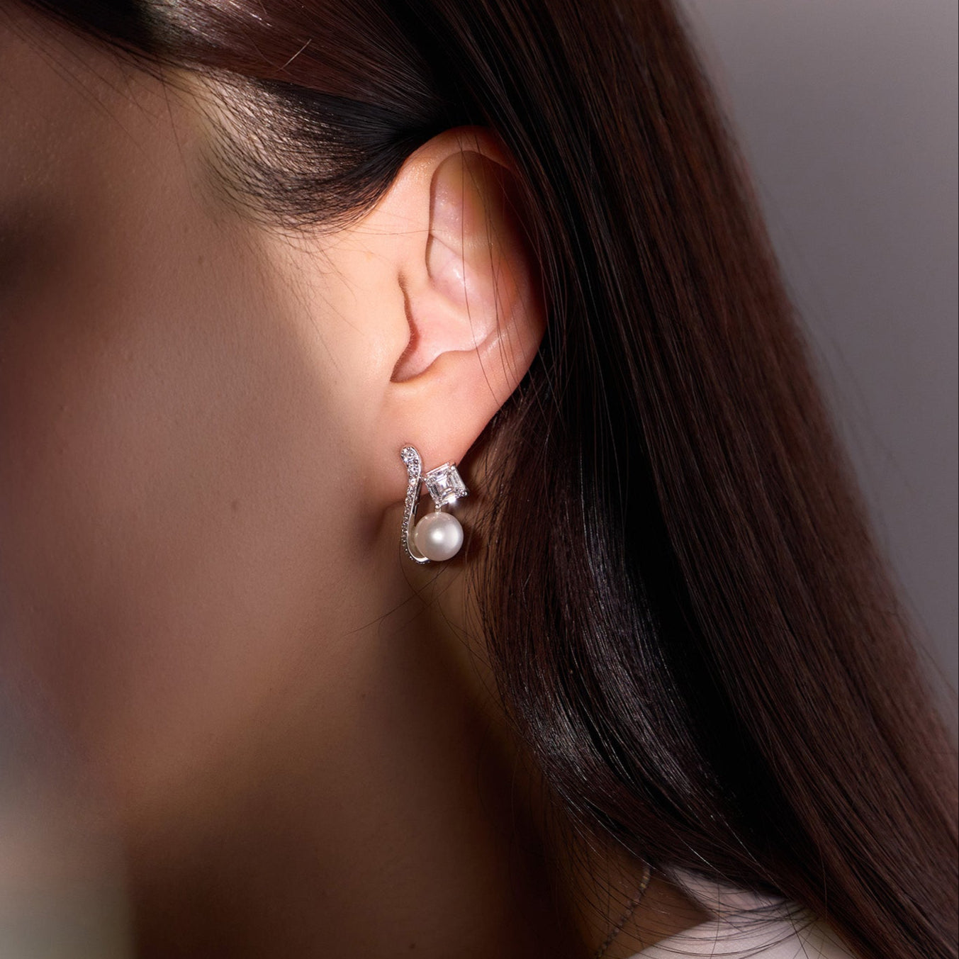 Pearl and Diamond Earrings featuring Asscher-cut diamonds and South Sea pearls with a sculptural pavé knife-edge design in white gold, worn on model
