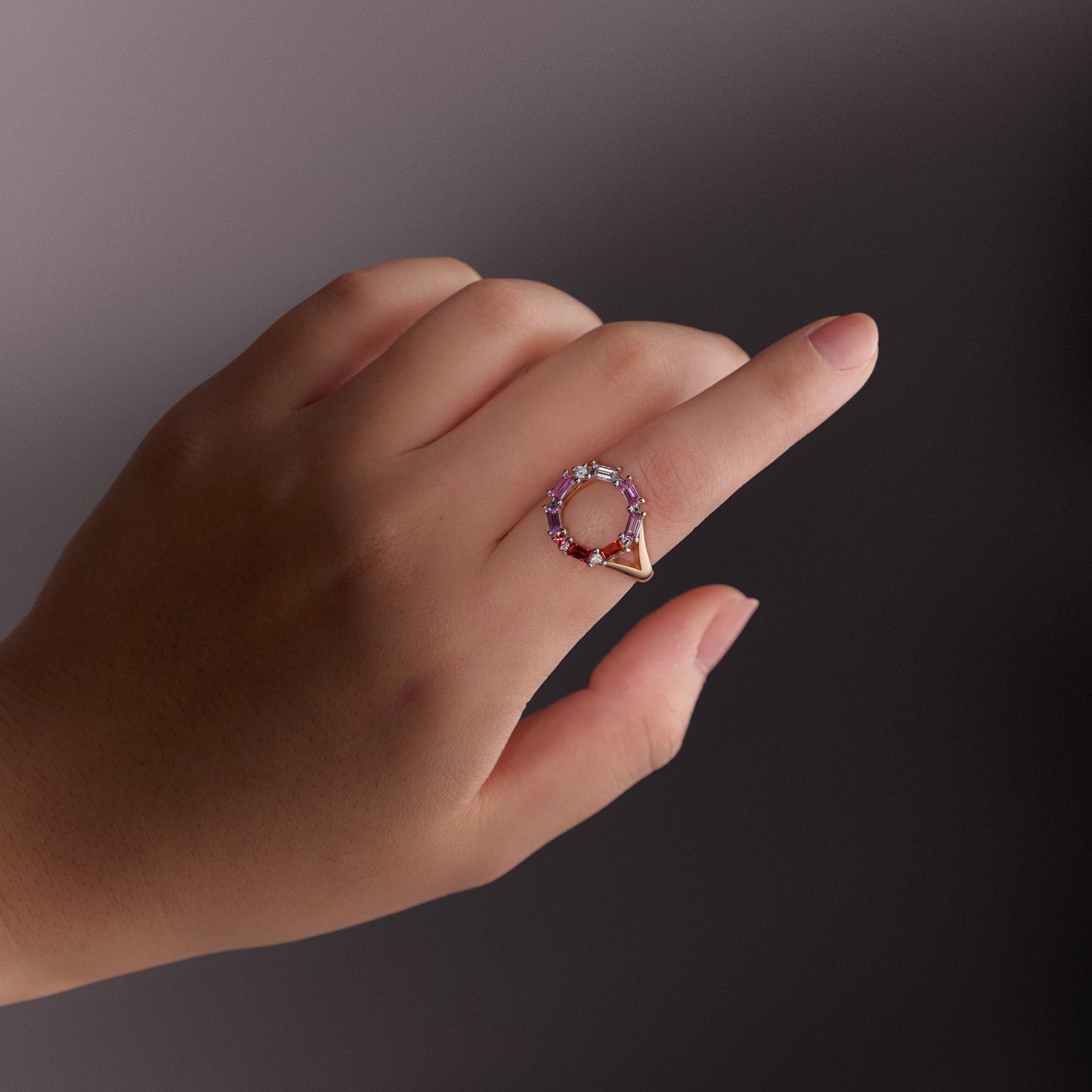 Bespoke Morse Code ring with diamonds, pink and orange sapphires in rose gold, worn on model.