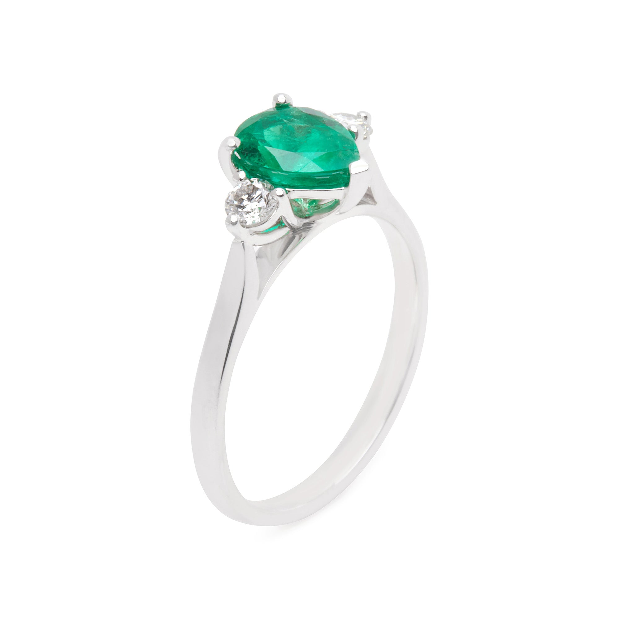 Pear-cut emerald trilogy ring with round white diamonds in 18k white gold, elegant and timeless design.