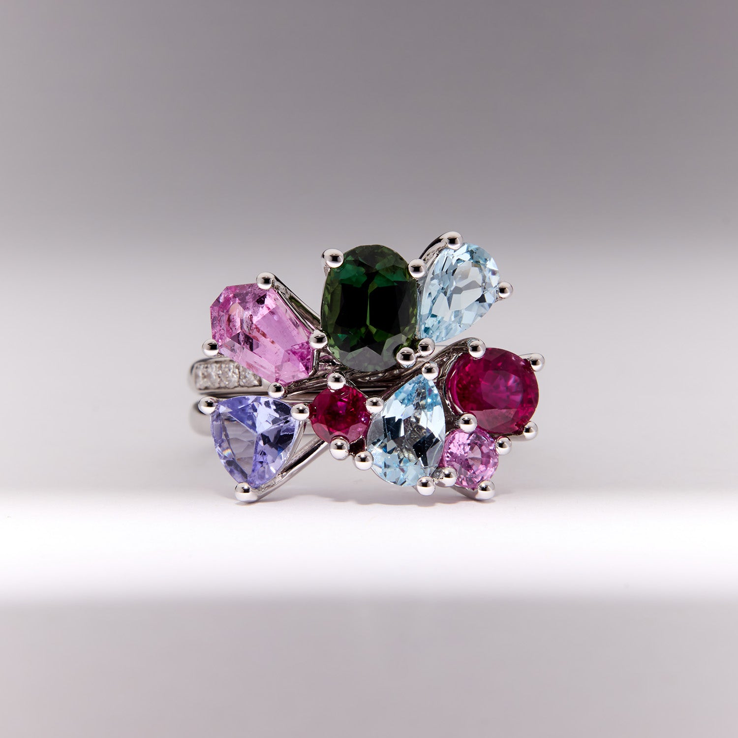 Heirloom Celestial Stack Ring in white gold with sapphires, rubies, tanzanite, topaz, and diamonds, interlocking celestial-inspired design.