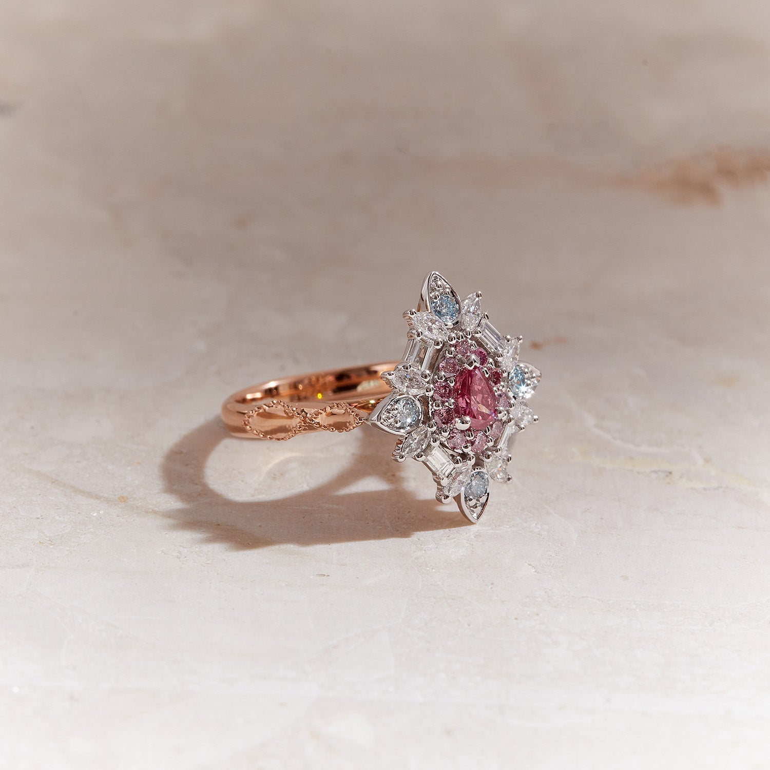 Emzo Kaleidoscope Ring with 1P pink Argyle diamond, blue and white diamonds in geometric floral design.