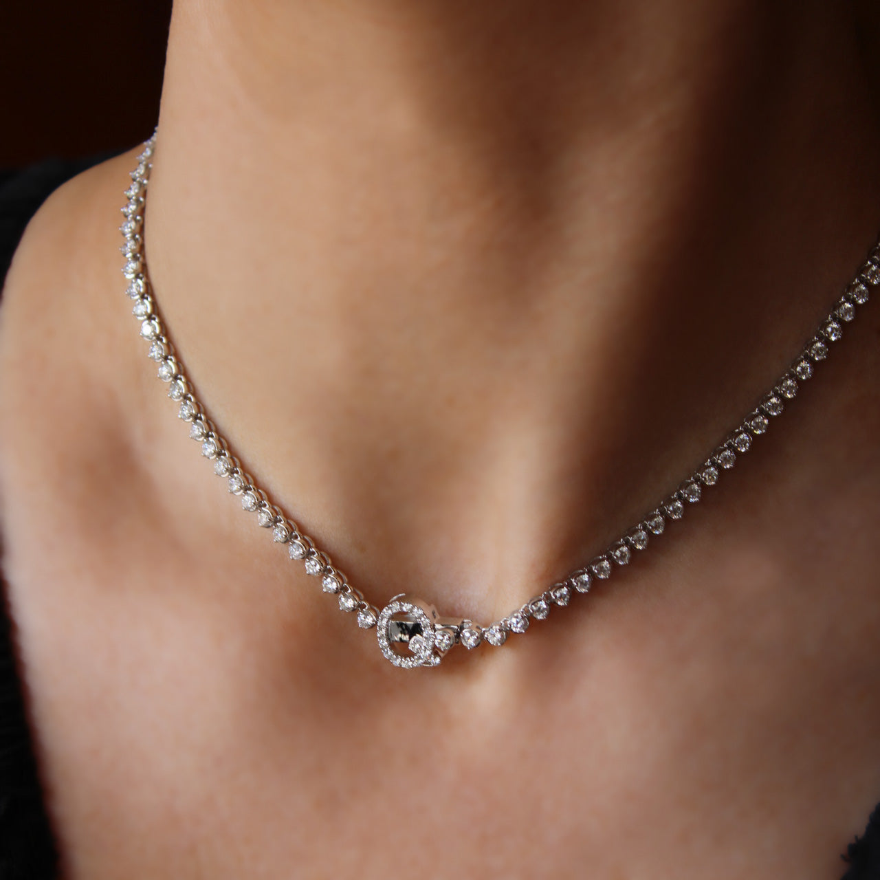 Bespoke graduated diamond tennis necklace with “Q” initial clasp in elegant design, worn on model.