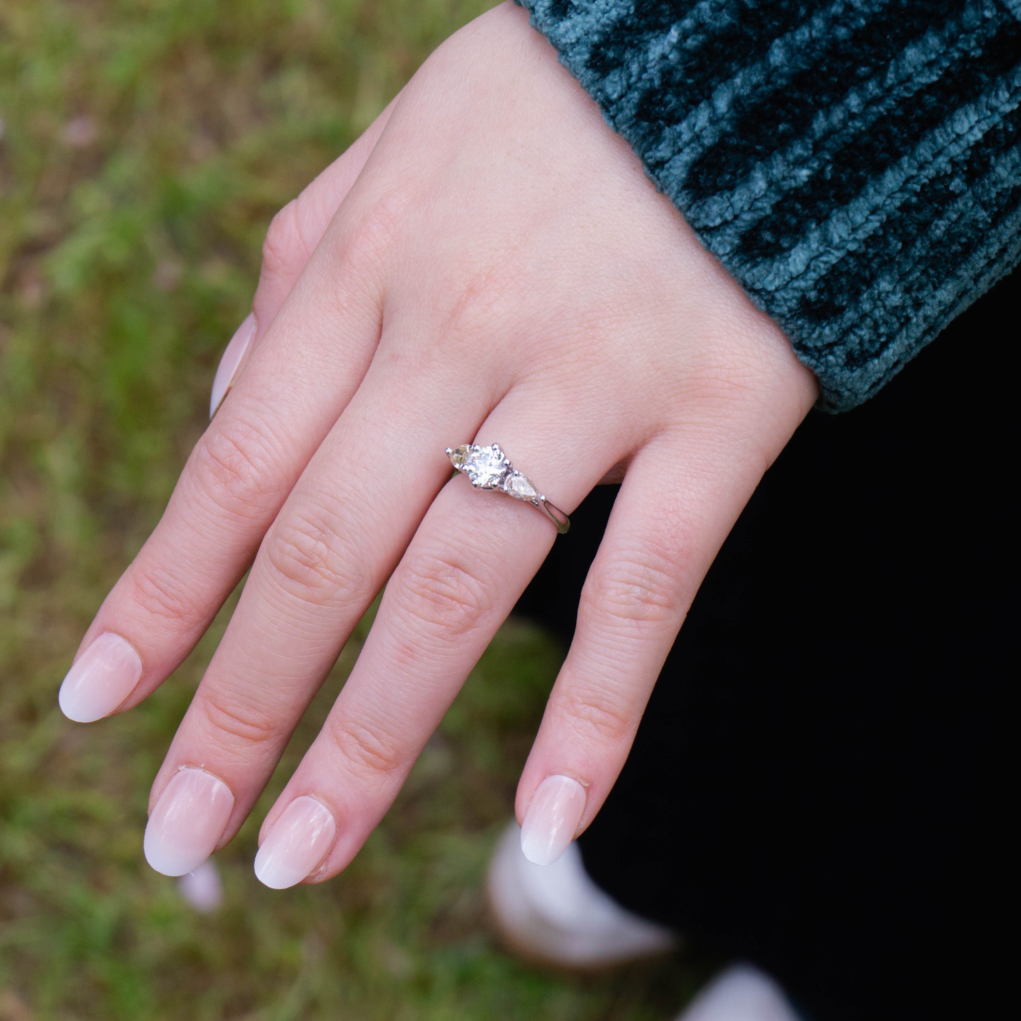 18k white gold Trilogy Engagement Ring featuring radiant round centre diamond and pear-cut pink & yellow side stones, timeless and modern, worn on hand.