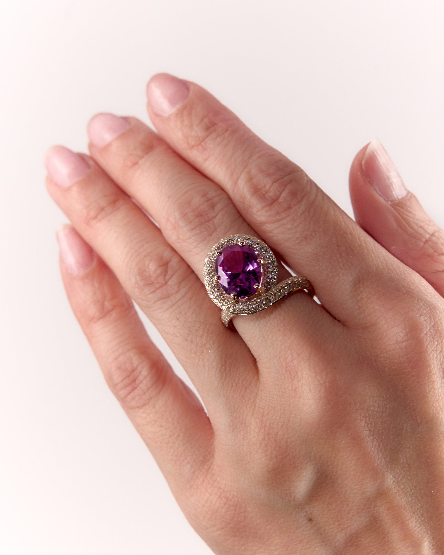 Suzi Ring in yellow gold with heirloom pink-purple gemstone and diamond accents, on hand model.