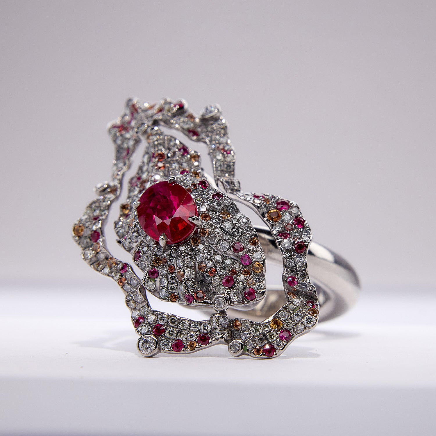 The Inferno Ring with Burmese ruby, diamonds, and orange sapphires in grey titanium, fiery and sculptural design