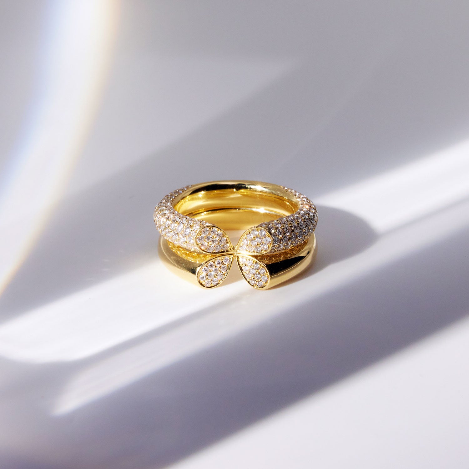 Wide diamond ring in 18k white gold with heart-shaped lily petal motif from Whispers of Love, stacked on each other.