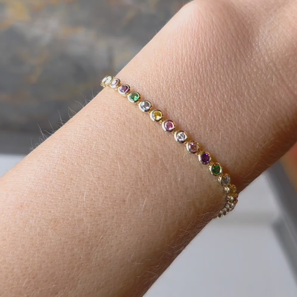 Faith Jewels Rainbow Tennis Bracelet featuring a vibrant mix of aquamarine, sapphires, white diamonds, garnet, peach, and amethyst gemstones totaling 2.80 carats, set in a sleek yellowngold chain