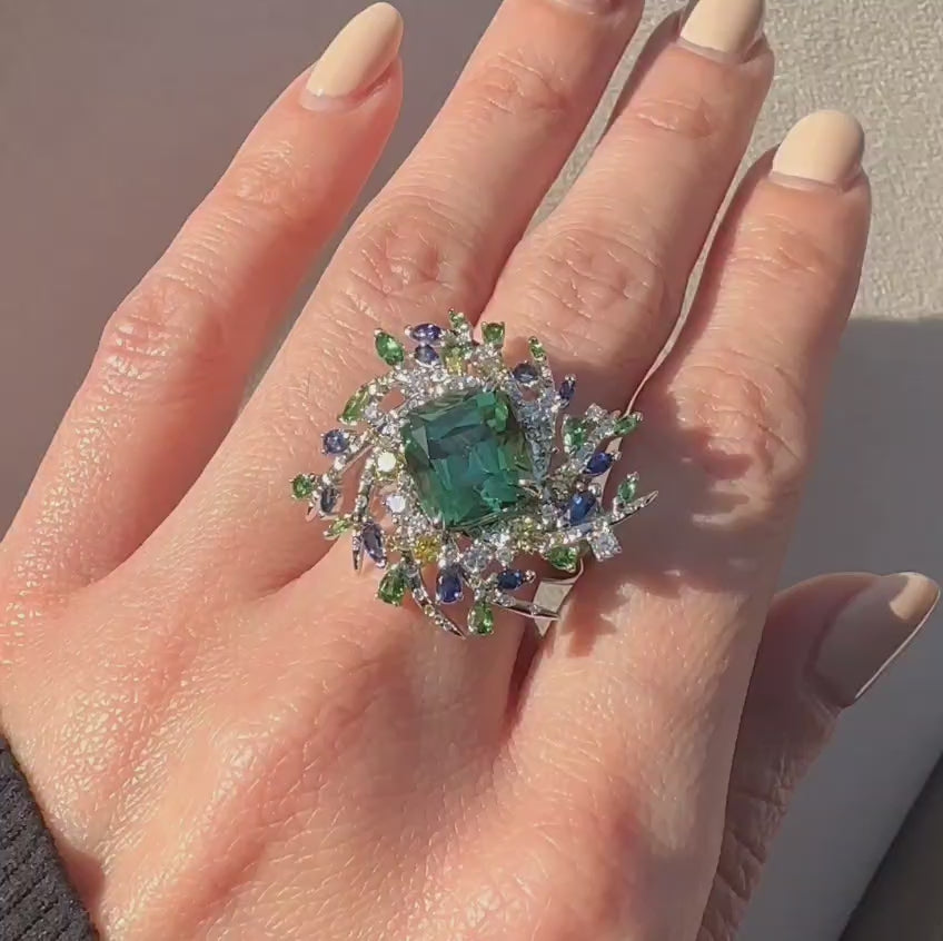 Nature-inspired ring with twig-like branches holding a vibrant mix of green, blue, and yellow sapphires and diamonds in white gold band