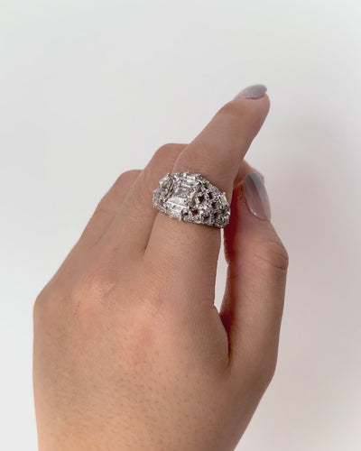 Pantheon Ring in white gold with emerald-cut diamond and architectural lattice of brilliant diamonds, shown in side view.