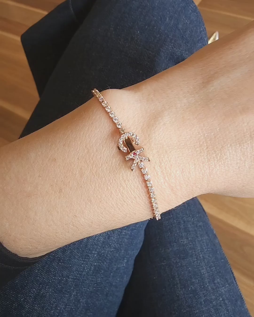 Faith Jewels bespoke initial diamond tennis bracelets in rose gold, each featuring a unique clasp shaped as a letter C and K — set with round brilliant-cut diamonds and red ruby