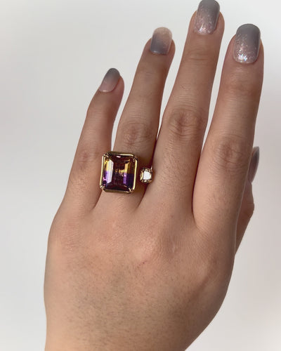 Unique Toi et Moi Ametrine Ring in yellow gold with emerald-cut ametrine and trapeze diamond, worn on hand model.